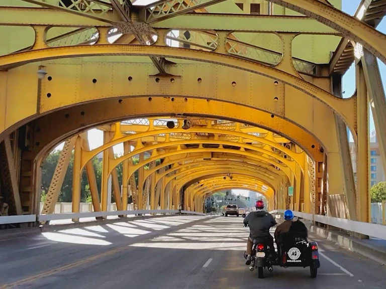 Riders in a sidecar tour across Tower Bridge near Old Town Sacramento.